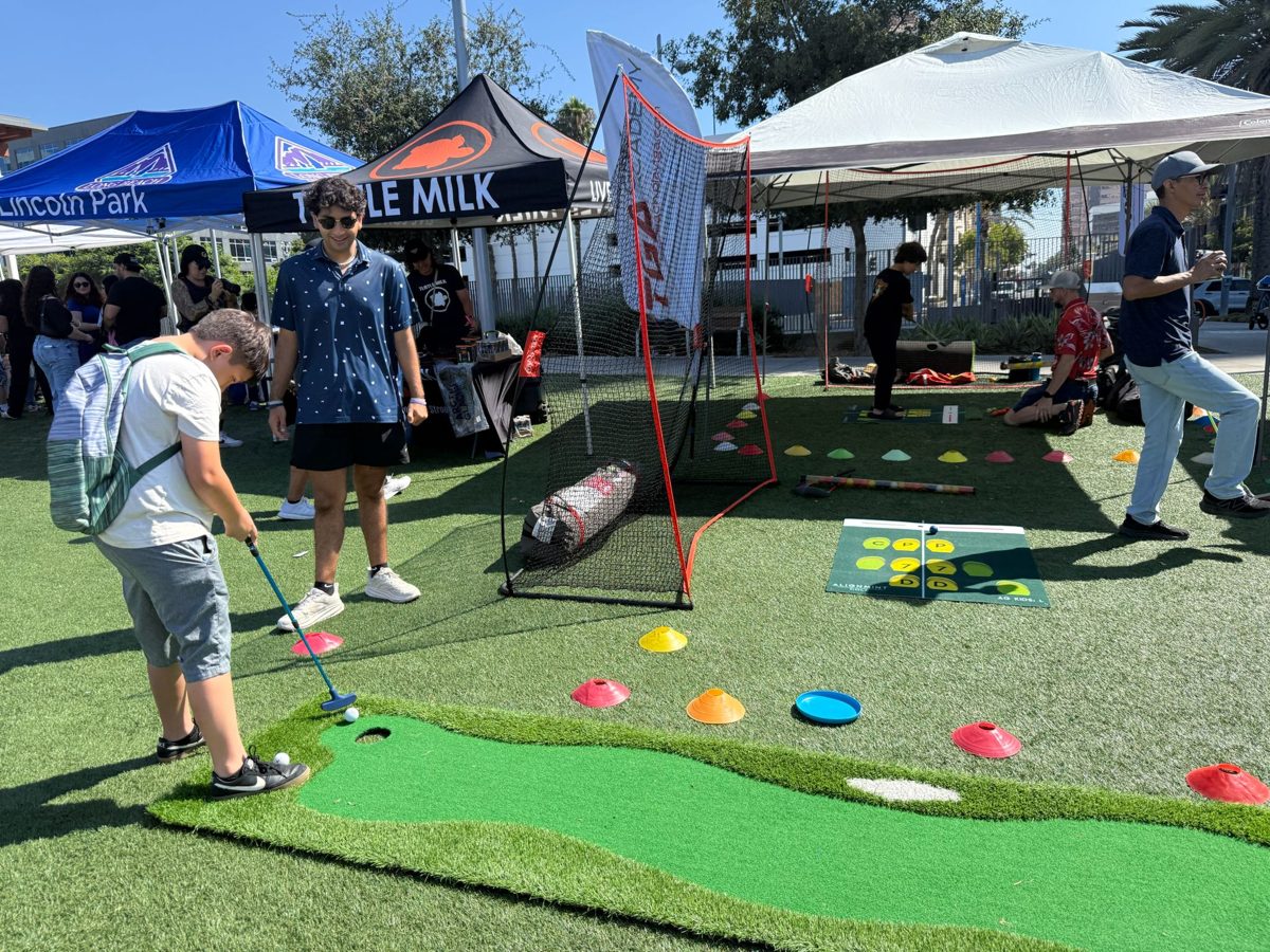 Youth practicing putting at the Annual DIG LIFE Youth Golf Clinic