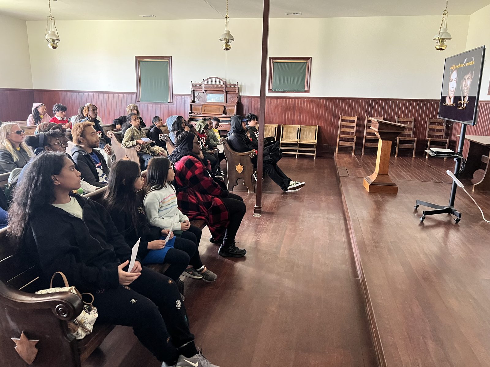 Students and families seated in the historic Allensworth church for a presentation on the town's founders.