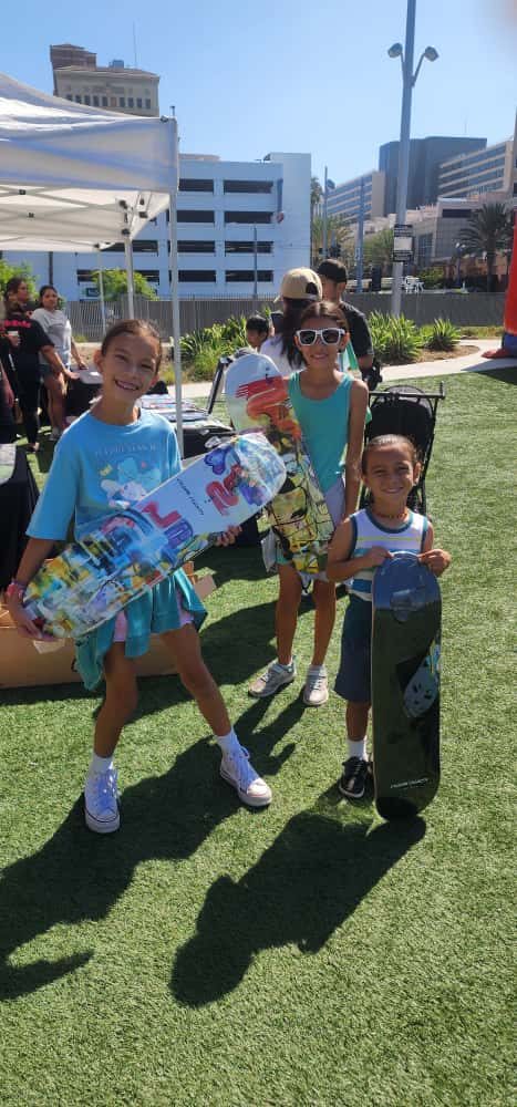 Three young skaters holding their brand-new skateboard decks.